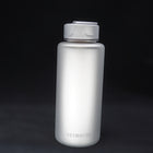 Titanium sport bottle, 700 ml, standing on black, the HEXMONDE wordmark near the base