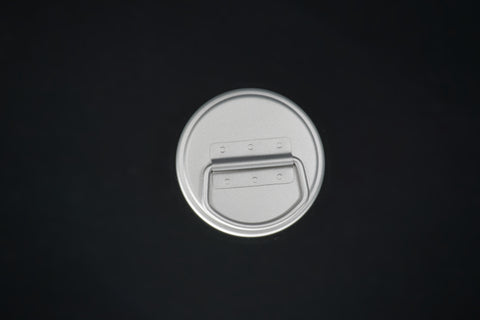 The bottle cap from above, its carry loop folded flat