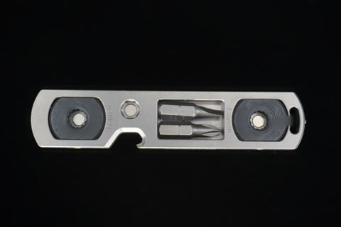 Titanium bit driver from the front, two bits stored between the ends marked Tighten and Loosen