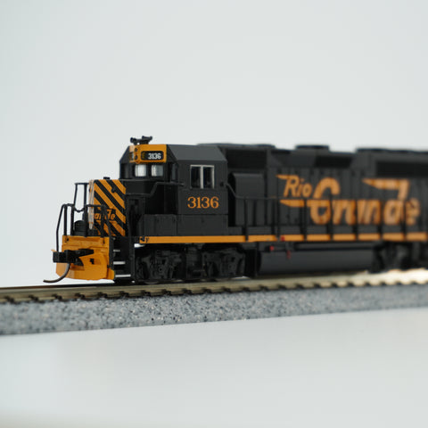 Close view of the Rio Grande GP40 locomotive in black and orange on display track.