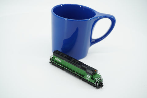 Cascade Green Burlington Northern SD45 locomotive beside a blue mug for scale; mug is not included.