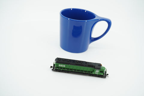 Side view of the Burlington Northern SD45 locomotive beside a blue mug for scale; mug is not included.